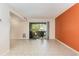 Bright living room with neutral tile floors, an orange accent wall, and sliding glass doors to a private patio at 10301 North Kings Hwy. # 13-5, Myrtle Beach, SC 29572
