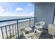 Relaxing balcony with white chairs and a table overlooking a scenic ocean view at 1105 South Ocean Blvd. # 1008, Myrtle Beach, SC 29577