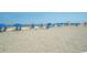 Beach scene with several blue umbrellas and lounge chairs dotting the sand at 1105 South Ocean Blvd. # 1008, Myrtle Beach, SC 29577