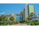 Wide shot of the Coral Beach Resort, showcasing its architecture and tropical landscaping at 1105 South Ocean Blvd. # 1008, Myrtle Beach, SC 29577