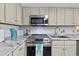 Well-appointed kitchen featuring stainless steel appliances, neutral cabinets, and stylish backsplash at 1108 N Waccamaw Dr. # C-4, Garden City Beach, SC 29576