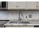 Kitchen sink with white marble counters, neutral backsplash, and stainless steel faucet at 1108 N Waccamaw Dr. # C-4, Garden City Beach, SC 29576