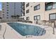 Community pool surrounded by lounge chairs and seating areas near condo building at 1108 N Waccamaw Dr. # C-4, Garden City Beach, SC 29576
