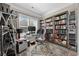 Home office with custom bookshelves, a large window, and a modern glass desk setup at 1129 Prescott Circle, Myrtle Beach, SC 29577
