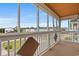 Balcony with wooden railing offers a view of colorful homes, foliage, and distant buildings at 113 B Vista Dr., Murrells Inlet, SC 29576