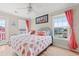 Comfortable bedroom showcasing bright coral bedding, hardwood floors, and scenic views from multiple windows at 113 B Vista Dr., Murrells Inlet, SC 29576