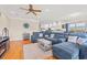 Spacious living room featuring a plush blue sectional, hardwood floors, ceiling fan, and an open floor plan at 113 B Vista Dr., Murrells Inlet, SC 29576