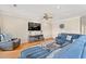Comfortable living room with a blue sectional sofa, entertainment center, ceiling fan, and hardwood floors at 113 B Vista Dr., Murrells Inlet, SC 29576