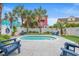 Backyard pool area featuring Adirondack chairs and lush landscaping, perfect for outdoor relaxation at 113 B Vista Dr., Murrells Inlet, SC 29576