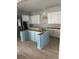 Bright kitchen with white cabinets, gold hardware, and light blue island offers a modern design at 1348 Rue De Jean Ave., Myrtle Beach, SC 29579
