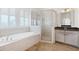 Bright bathroom featuring a soaking tub, glass shower, and white cabinets at 1359 Peterson St., Myrtle Beach, SC 29577