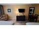 Comfortable living area featuring a dresser with a TV, lamp, table and chairs plus an armchair at 1501 S Ocean Blvd. # 320, Myrtle Beach, SC 29577