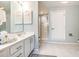 A bathroom features double sinks, white cabinets, a large mirror, white cabinets, and a glass shower at 1608 Harbor Dr., North Myrtle Beach, SC 29582