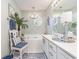 A traditional-style bathroom with double sinks, white cabinets, a soaking tub and blue accents at 1608 Harbor Dr., North Myrtle Beach, SC 29582