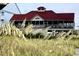 Coastal home with a red roof, screened porch, and picturesque views of beach grasses at 1608 Harbor Dr., North Myrtle Beach, SC 29582
