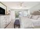 A bright main bedroom features a sliding door to a balcony, a ceiling fan, a dresser, and a neutral color palette at 1608 Harbor Dr., North Myrtle Beach, SC 29582