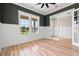 Bright living room featuring a hardwood floor, large windows, and a glass-panel door to an office at 209 Bouquets Green Way, Myrtle Beach, SC 29579