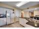 Well-lit kitchen equipped with white cabinetry, granite countertops, a refrigerator, and an adjacent dining area at 2151 Bridge View Ct. # 2-803, North Myrtle Beach, SC 29582