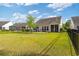Spacious backyard with a lush lawn, fenced perimeter, and a view of the home's exterior at 2446 Craven Dr., Myrtle Beach, SC 29572