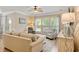 A cozy living room offers a ceiling fan, plush seating, and three large windows at 2446 Craven Dr., Myrtle Beach, SC 29572
