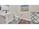 Neutral toned bathroom offers pedestal sink, toilet, and decorative area rug at 25 Northwoods Ct., Pawleys Island, SC 29585