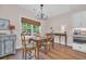 Charming dining room with wood floors, a rustic chandelier, and serene views from large windows at 25 Northwoods Ct., Pawleys Island, SC 29585