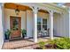 Inviting front porch with seating, a wood ceiling, brick floor, and decoratively potted plants at 25 Northwoods Ct., Pawleys Island, SC 29585