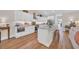 Bright, modern kitchen features white cabinets, stainless steel appliances, granite countertops, and wood flooring at 25 Northwoods Ct., Pawleys Island, SC 29585