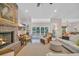 Bright living room with fireplace, plush seating, and large windows offering scenic backyard views at 25 Northwoods Ct., Pawleys Island, SC 29585