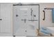 Modern walk-in shower with a glass door, white tile, and sleek hardware at 25 Northwoods Ct., Pawleys Island, SC 29585