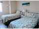 Cozy bedroom features twin beds, tropical bedding, and beach-themed wall art at 2507 S Ocean Blvd. S, North Myrtle Beach, SC 29582