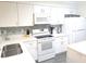 Modern all-white kitchen with stainless steel appliances and a stylish backsplash at 2507 S Ocean Blvd. S, North Myrtle Beach, SC 29582