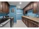 Well-lit laundry room featuring a granite countertop, wooden cabinets, and front-load washer and dryer at 256 Shoreward Dr., Myrtle Beach, SC 29579