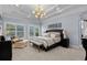 Relaxing main bedroom features tray ceiling, chandelier lighting and seating area near bright windows at 256 Shoreward Dr., Myrtle Beach, SC 29579