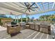 Outdoor kitchen with stainless steel appliances, grill, stone countertop, ceiling fans, and lake views at 256 Shoreward Dr., Myrtle Beach, SC 29579