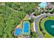 Aerial view of community tennis court, basketball court, and winding paved roads with mature trees at 2600 Henagan Ln., Myrtle Beach, SC 29588