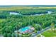 Aerial view of community pool surrounded by lush trees, homes, and a serene lake at 2600 Henagan Ln., Myrtle Beach, SC 29588