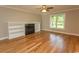 Bright living room featuring hardwood floors, a fireplace with built-in shelving, and a large window at 2600 Henagan Ln., Myrtle Beach, SC 29588