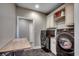 Functional laundry room with a folding table, upper cabinets, and modern washer and dryer at 2767 Lees Landing Circle, Conway, SC 29526