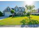 Charming two-story home with a well-manicured lawn, lush landscaping, and a welcoming front entrance at 304 San Martin Ct., Longs, SC 29568