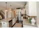 Open kitchen features granite countertops, stainless steel appliances, white cabinets and hardwood floors at 304 San Martin Ct., Longs, SC 29568
