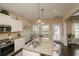 Open kitchen features granite countertops, stainless steel appliances, white cabinets and hardwood floors at 304 San Martin Ct., Longs, SC 29568