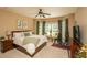 Comfortable main bedroom with bay windows, ceiling fan, and exercise equipment at 304 San Martin Ct., Longs, SC 29568