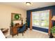 Cozy office featuring natural light, elegant desk, and blue accent wall creating a refined and productive workspace at 304 San Martin Ct., Longs, SC 29568