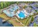Aerial view of a resort-style swimming pool area with palm trees, a splash pad, and a playground at 3119 Hannon Dr., Myrtle Beach, SC 29579