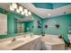 Spa bathroom featuring a large soaking tub, double vanity and bright teal paint and lighting at 3601 S Ocean Blvd. # 8-C, North Myrtle Beach, SC 29582
