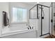 Bright bathroom featuring a soaking tub, separate shower, and modern fixtures for a relaxing spa-like experience at 370 Foxtail Dr., Longs, SC 29568