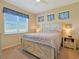 Cozy bedroom with a rustic wood bed frame, three large windows with blinds, and soft neutral decor at 3766 Bells Lake Circle # 3766, Longs, SC 29568