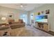 Comfortable living room featuring wood-look floors, a ceiling fan, access to the porch, and a TV with barnwood stand at 3766 Bells Lake Circle # 3766, Longs, SC 29568