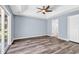 Bright bedroom featuring vinyl flooring, a tray ceiling, ceiling fan, and backyard access at 389 Barton Loop, Myrtle Beach, SC 29579